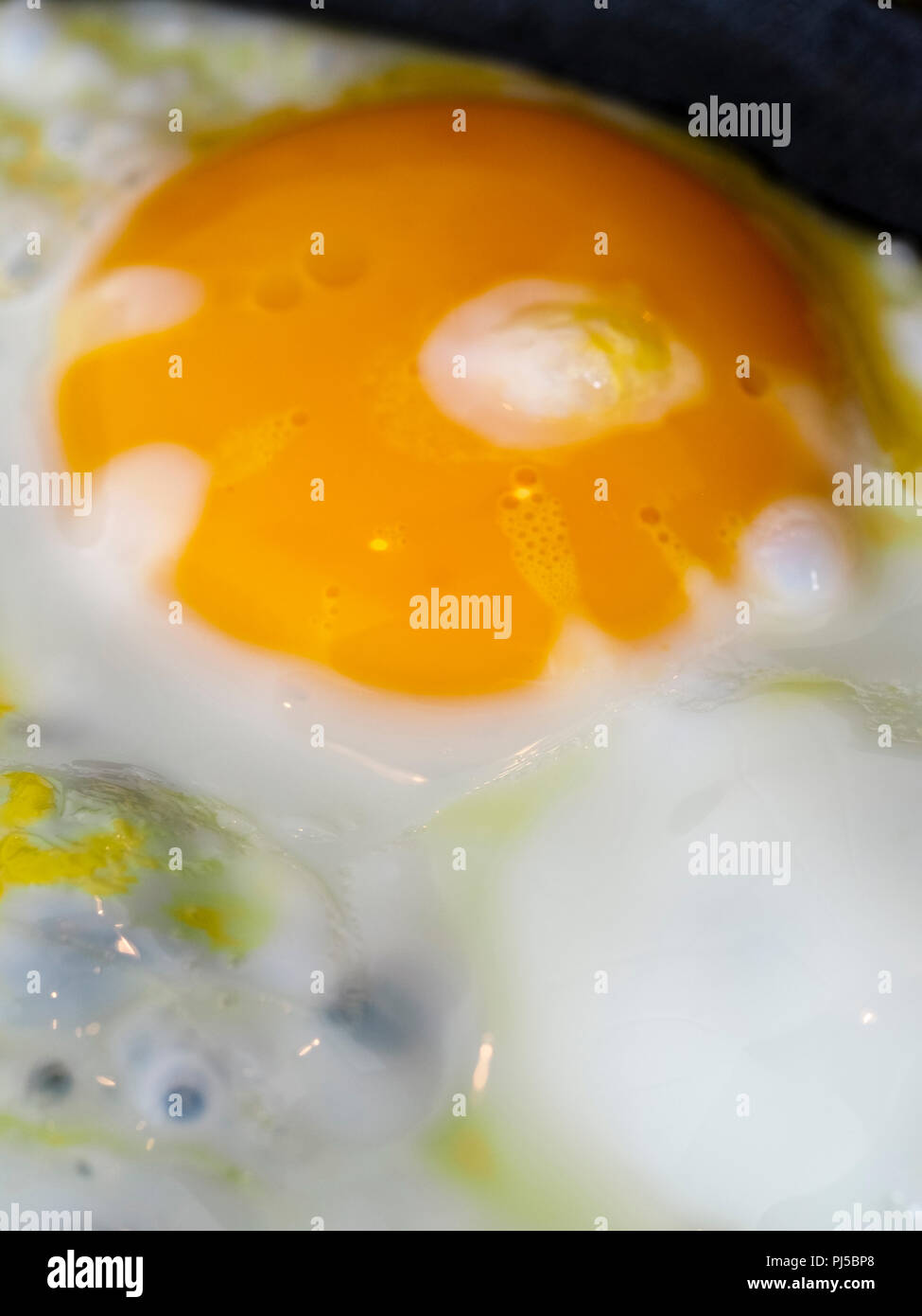 Frying eggs in a dark pan with butter Stock Photo Alamy