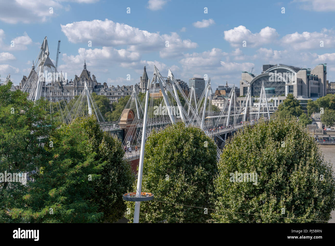 Hungerford bridge and Charing Cross station from the top of the Festival Hall. This side of the station is a Post Modern building by Terry Farrell. Stock Photo