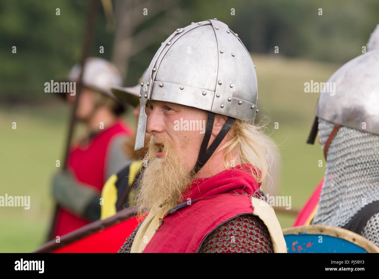 Medieval battle re-enactment with men wearing a spangenhelm helmet Stock Photo