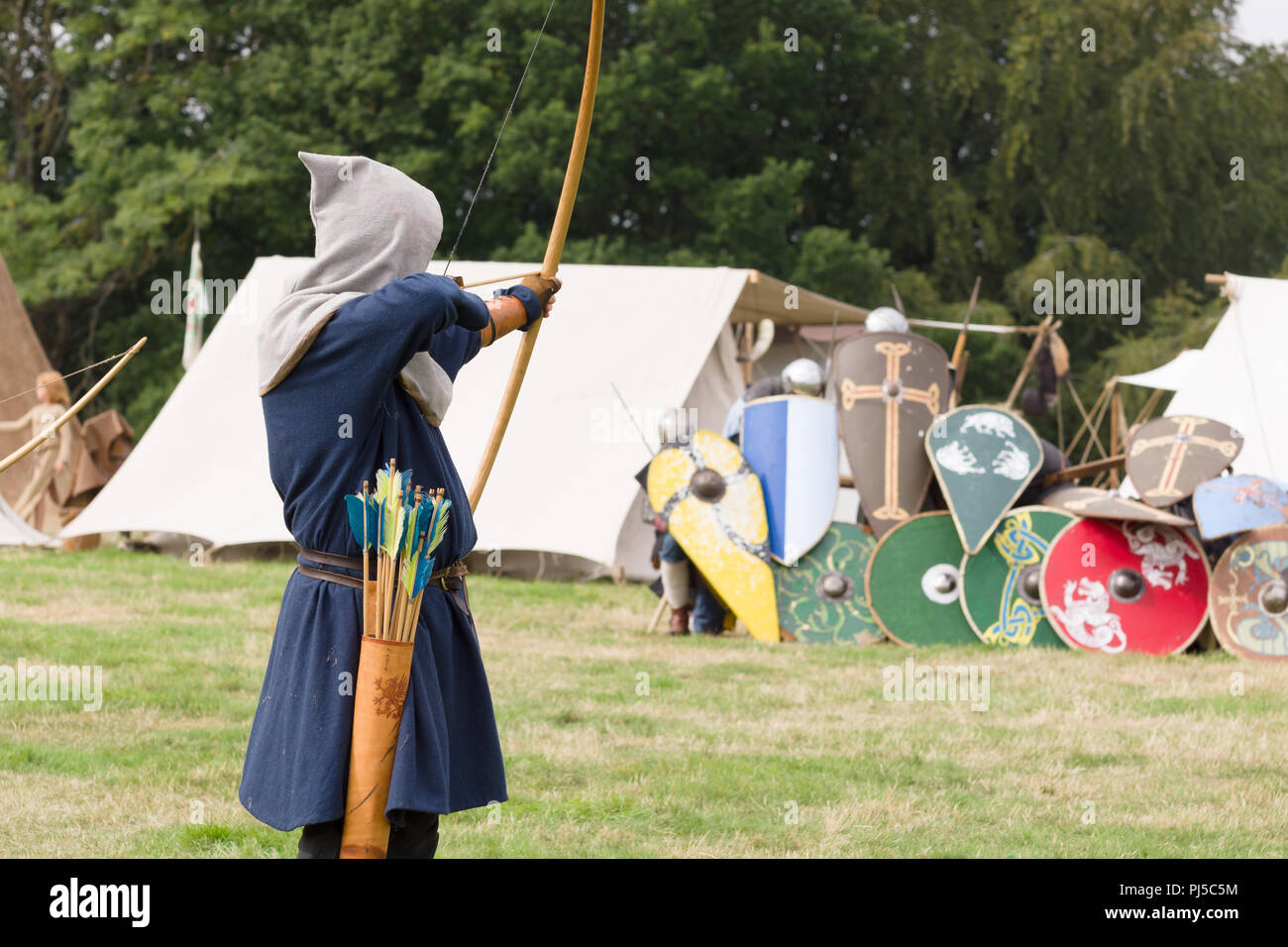 Medieval battle with an archer shooting arrows part of the Cwmwd Ial society re-enacting the battle of Crogen 1165 in Chirk North Wales Stock Photo