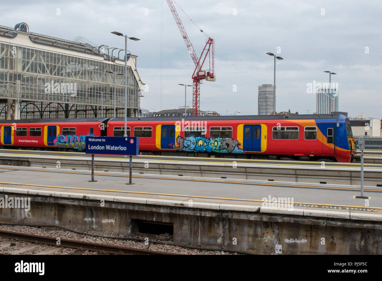 graffiti on the side of a southwestern railway train in the platform at London waterloo railway station in central london Stock Photo