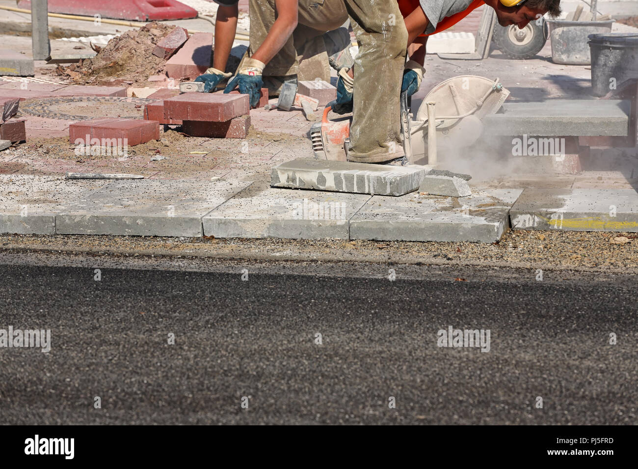 worker laying concrete slabs on sidewalk Stock Photo