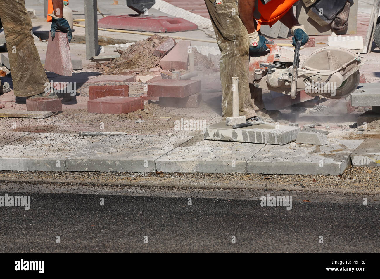 worker preparing concrete blocks for pavement Stock Photo