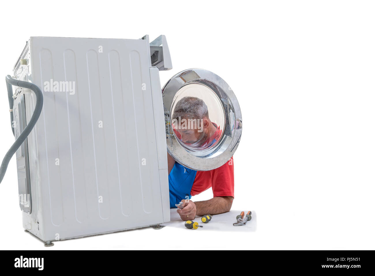 plumbing. Plumber repairing washing machine on white background Stock Photo