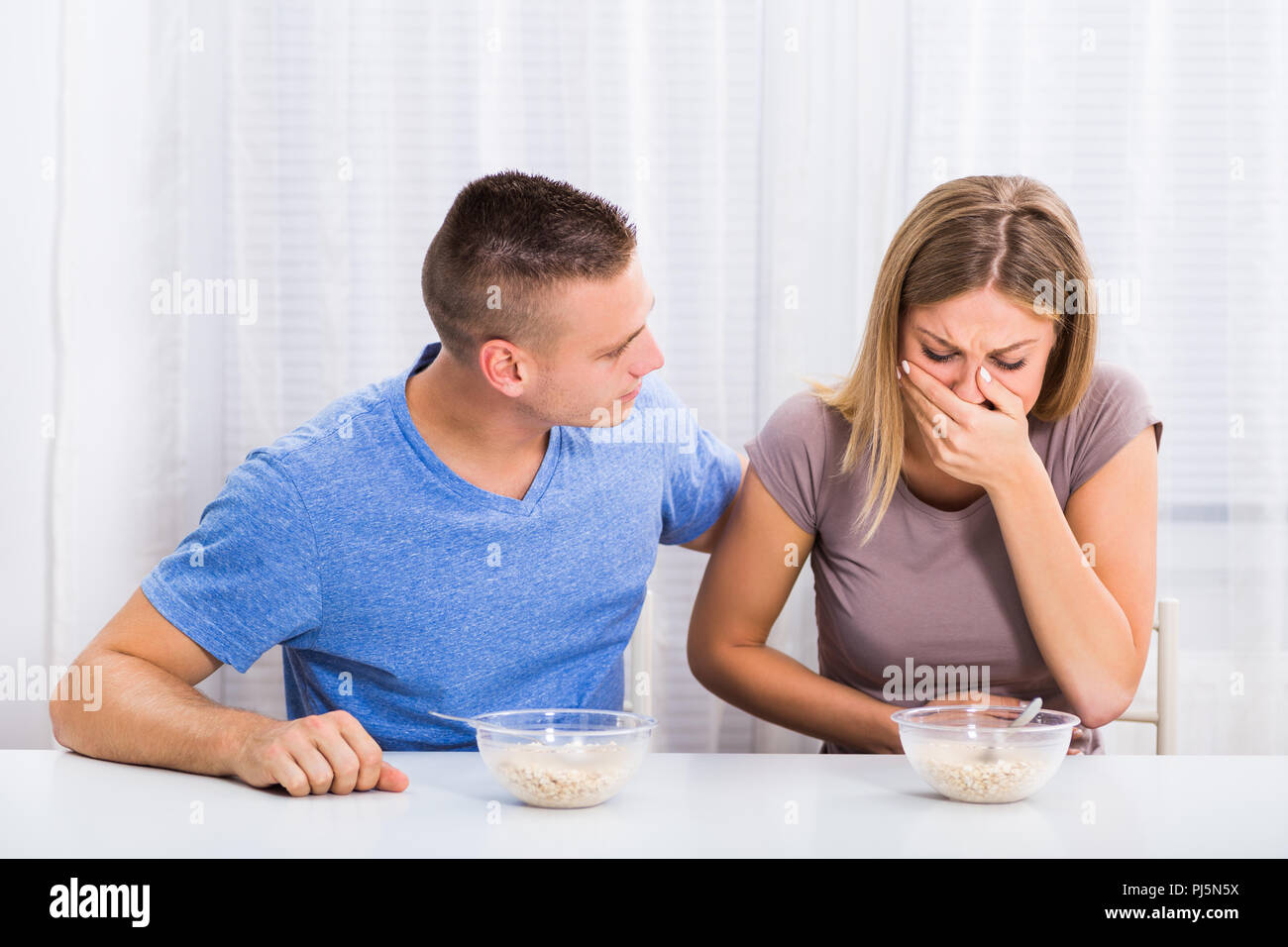 Husband is consoling his wife because she feel nausea Stock Photo