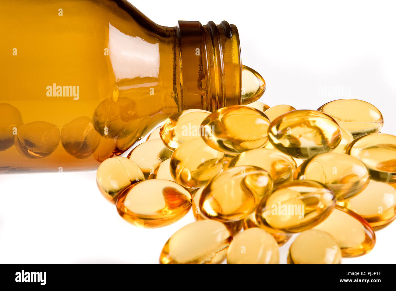 Medicine bottle filled with golden gel capsules Stock Photo Alamy
