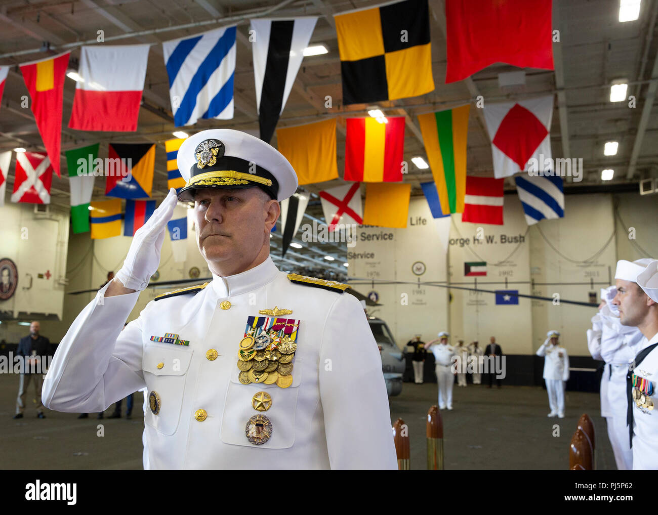 180824-N-IK388-0008 NORFOLK (Aug. 24, 2018) Adm. Chris Grady, commander, U.S. Fleet Forces Command, salutes the sideboys as he arrives to the U.S. 2nd Fleet establishment ceremony aboard the nuclear aircraft carrier USS George H.W. Bush (CVN 77). U.S. 2nd Fleet will exercise operational and administrative authorities over assigned ships, aircraft and landing forces on the East Coast and North Atlantic. (U.S. Navy photo Mass Communication Specialist 2nd Class Stacy M. Atkins Ricks/Released) Stock Photo