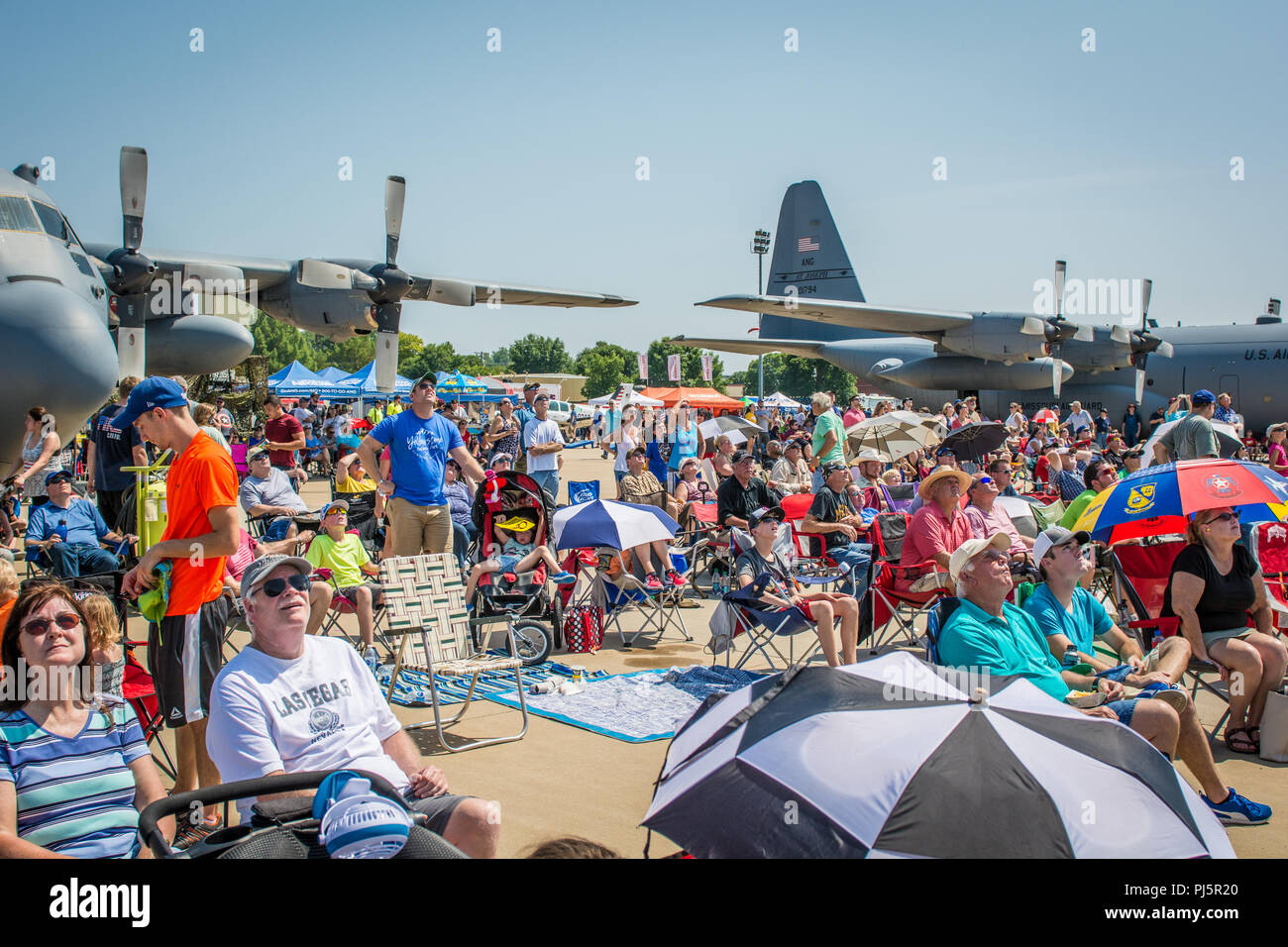 Attendees of the Sound of Speed Airshow look towards the sky at