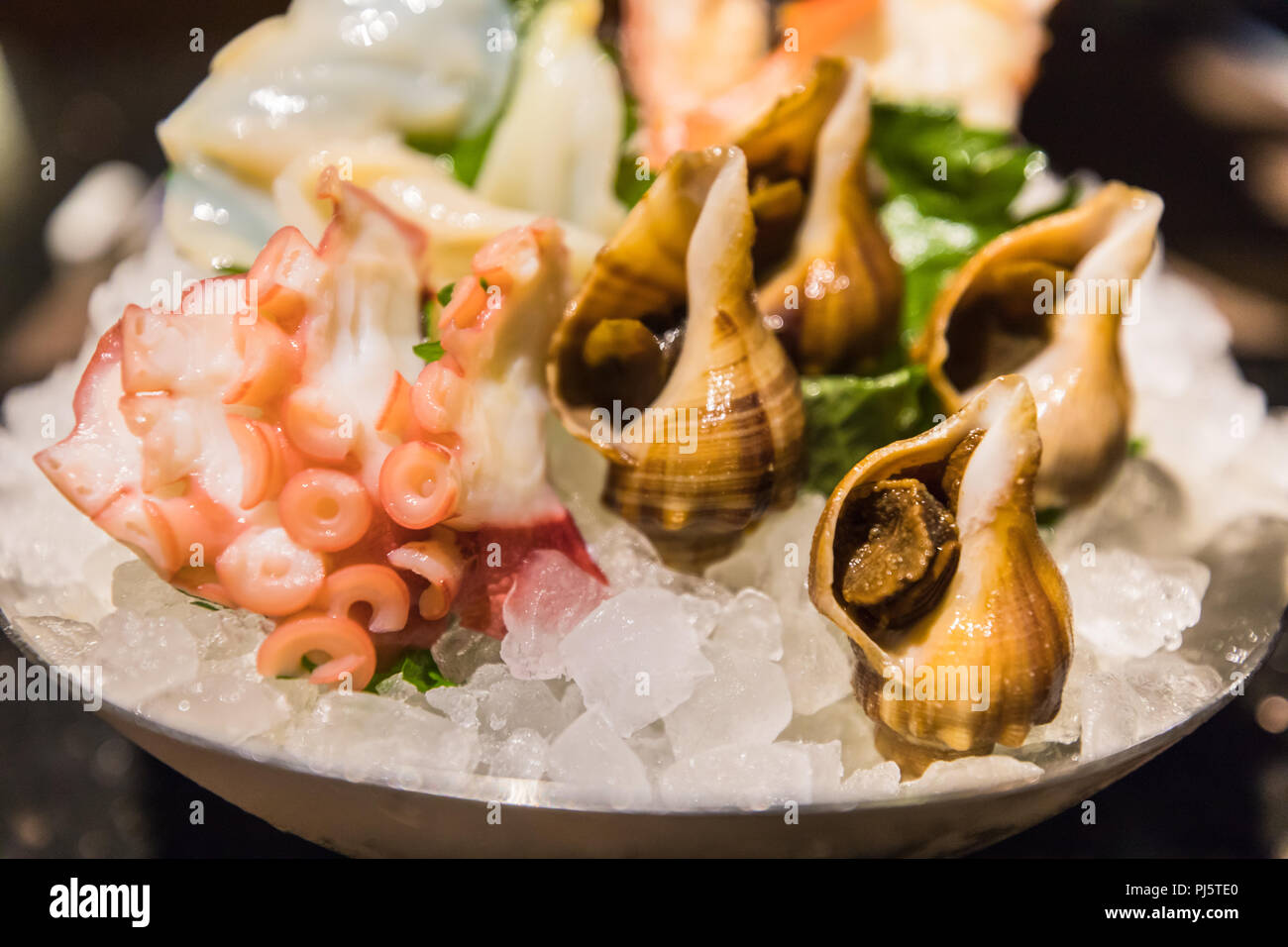 Closeup view of typical Japanese food Sashimi,  a Japanese delicacy consisting of very fresh raw meat, fish, seafood sliced into thin pieces. Stock Photo