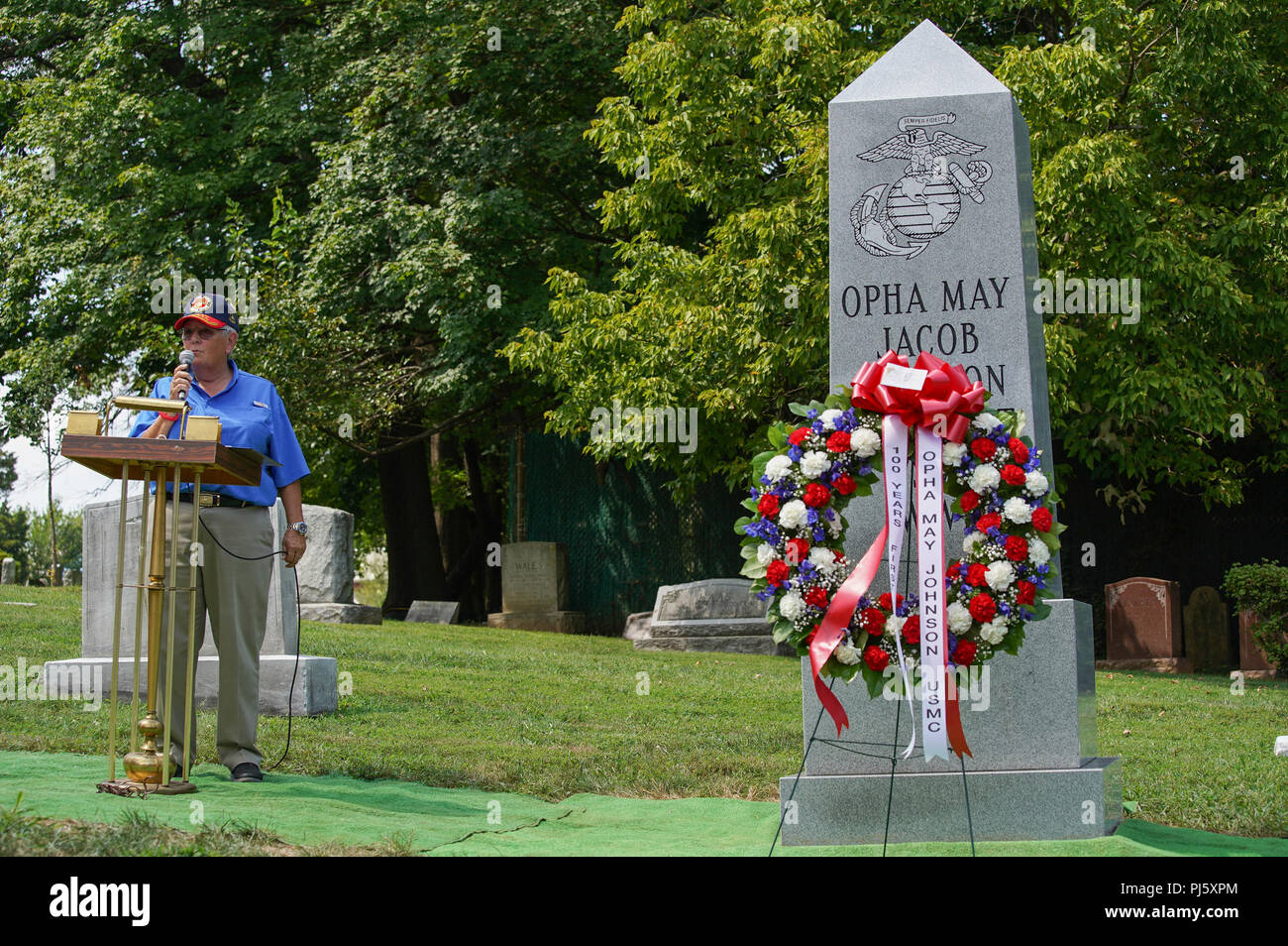 Kathy Sheppard, committee chair, Women Marines Association, gives remarks during the unveiling of a monument at the gravesite of Opha May Johnson, St. Paul’s Rock Creek Cemetery, Washington, D.C., Aug. 29, 2018. The monument was put up by the Women Marines Association to commemorate the 100 years of women serving in the Marine Corps. (U.S. Marine Corps photo by Cpl. Paul A. Ochoa) Stock Photo