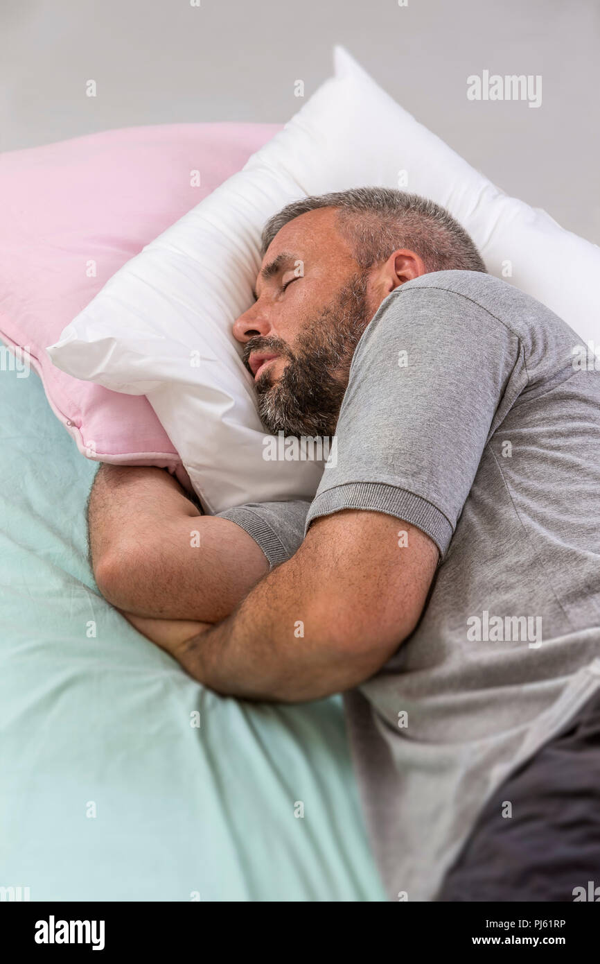 Happy to Sleep. Young Man Sleeping on his Bed With Eyes Closed Stock Photo