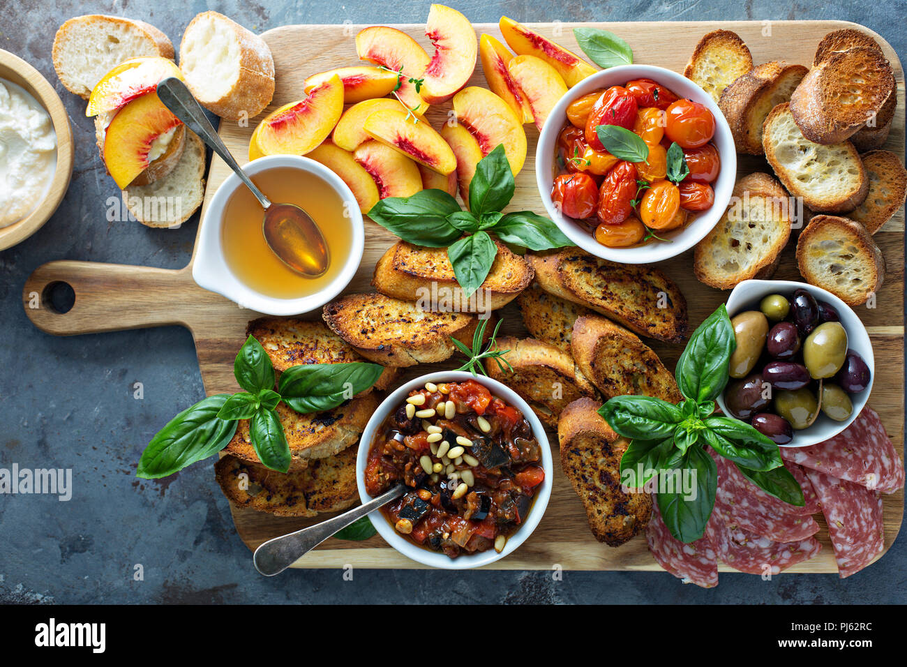 Crostini board with tomatoes, peaches and eggplant caponata dip Stock