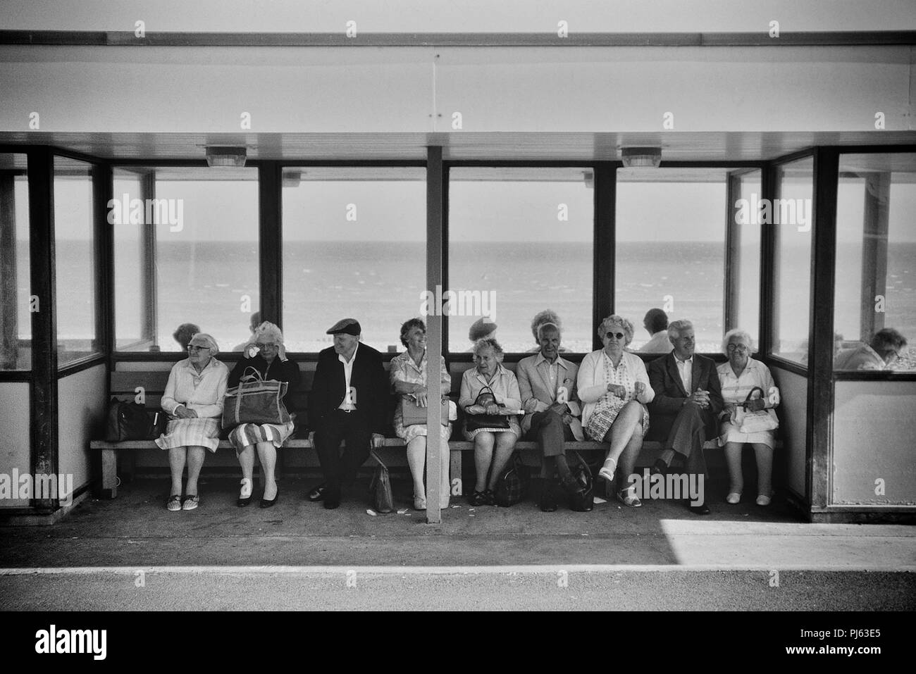 Pensioners sitting in a seafront shelter, Margate, Thanet, England, UK. Circa 1980's Stock Photo