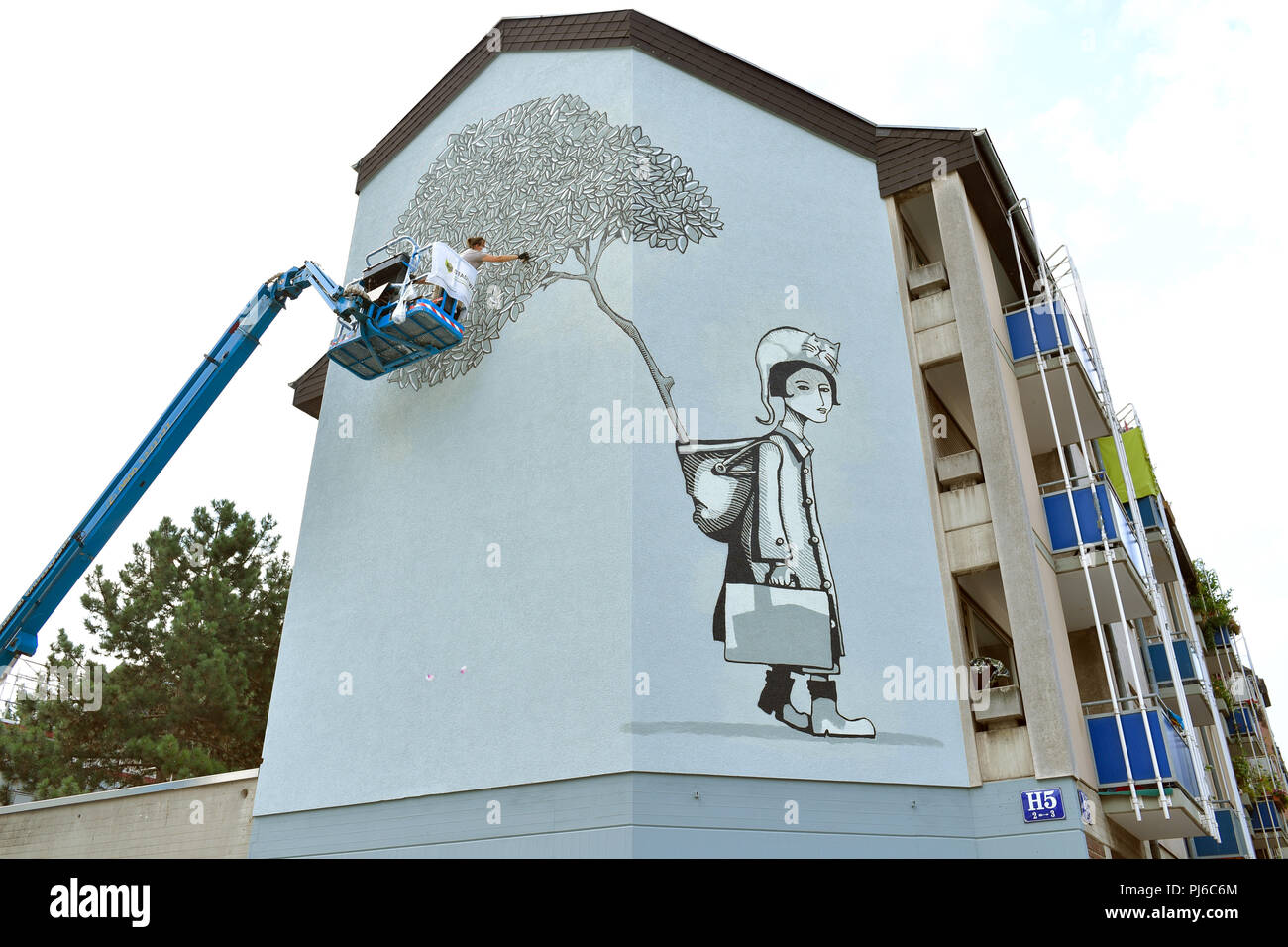 Mannheim, Germany. 23rd Aug, 2018. 23.08.2018, Baden-Württemberg, Mannheim: Christina Laube of the artist duo 'Sourati' sprays a mural entitled 'Abschied und Neubeginn' (lit. Farewell and new beginning) on a house wall. At the end of the year, 18 huge works of art will be displayed on the facades of the North Baden city. Credit: Uwe Anspach/dpa/Alamy Live News Stock Photo