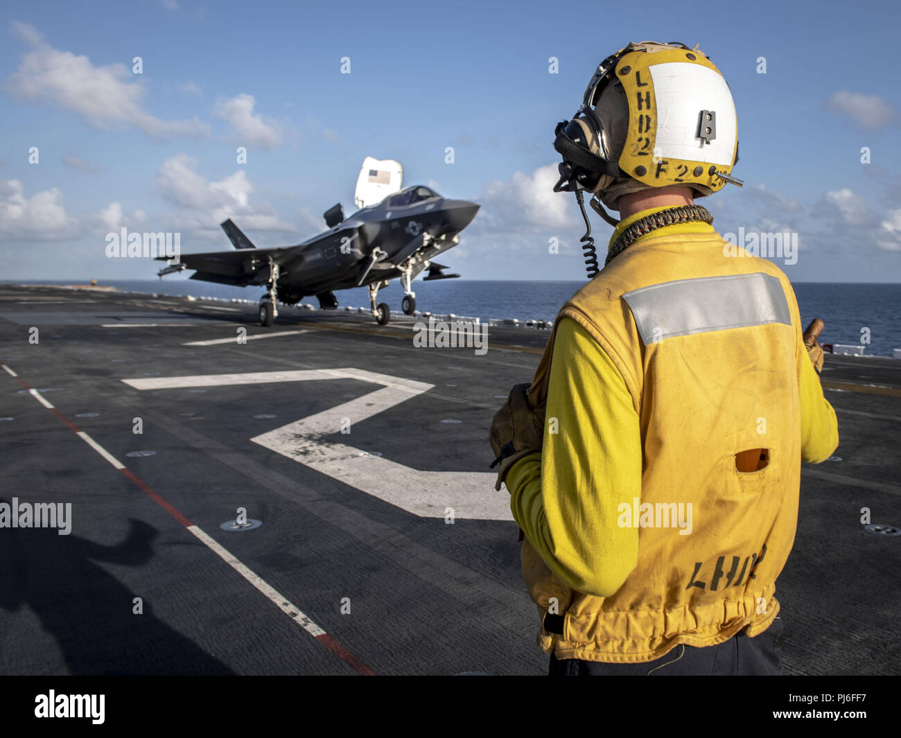 Indian Ocean. 8th Mar, 2018. INDIAN OCEAN (Sept. 1, 2018) Aviation Boatswain's Mate (Handling) Airman Daigan Bishop signals an F-35B Lightning II attached to the Avengers of Marine Fighter Attack Squadron (VMFA) 211 as it launches from the flight deck of the Wasp-class amphibious assault ship USS Essex (LHD 2) during a scheduled deployment of the Essex Amphibious Ready Group (ARG) and the 13th Marine Expeditionary Unit (MEU). The Essex ARG/13th MEU is a lethal, flexible, and persistent Navy-Marine Corps team deployed to the U.S. 5th Fleet area of operations in support of naval operations t Stock Photo