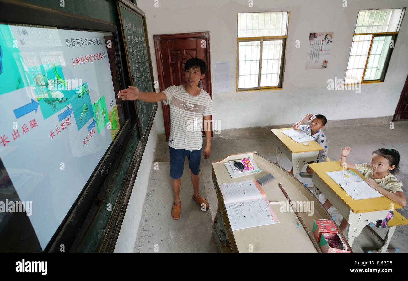 (180905) -- ZHANGSHU, Sept. 5, 2018 (Xinhua) -- Teacher Huang Wenchun teaches a lesson for grade two at Luling teaching point in Dianxia Township in Zhangshu City, east China's Jiangxi Province, Sept. 4, 2018. As a teacher at Luling teaching point, Chen Yungen has been teaching for 50 years. Graduated from a junior high school, Chen Yungen began teaching at Luling teaching point in 1968. Over the past dacades, a total of 30 students went to the universities, including two with master's degree and one with doctorate. In 2007, Chen Yungen was awarded 'national model teacher'. His student Huang W Stock Photo