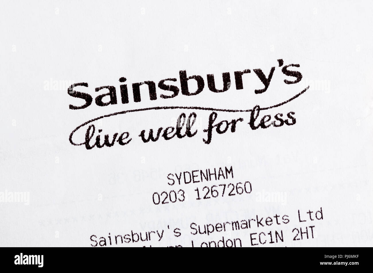 Closeup of Sainsbury's live well for less slogan printed on a till