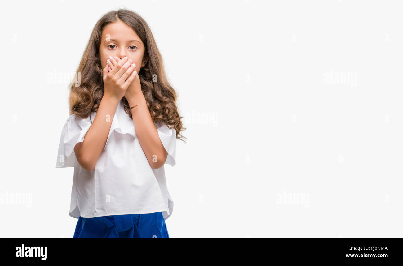 Brunette hispanic girl shocked covering mouth with hands for mistake. Secret concept. Stock Photo