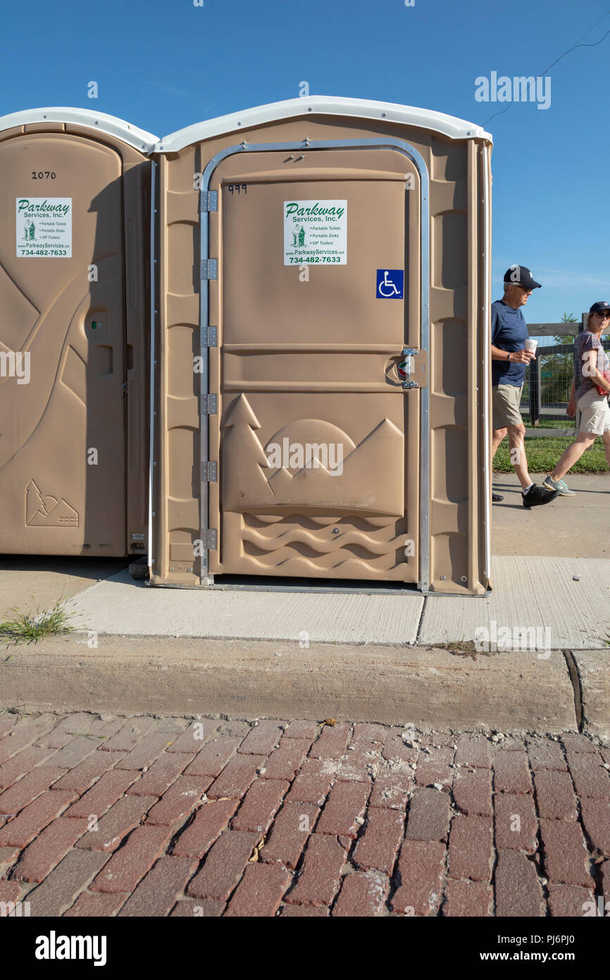 Detroit, Michigan - A portable restroom designed for wheelchair users set up near a curb which prevents wheelchair access. Stock Photo