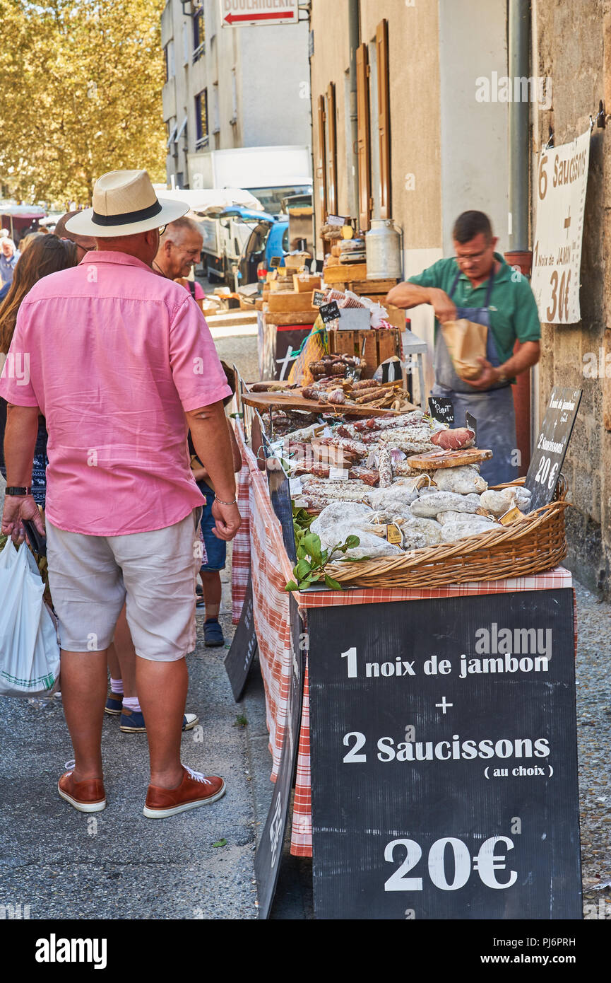 Market trader selling meats during the market at Lamastre, Ardeche, Rhone Alps, France Stock Photo