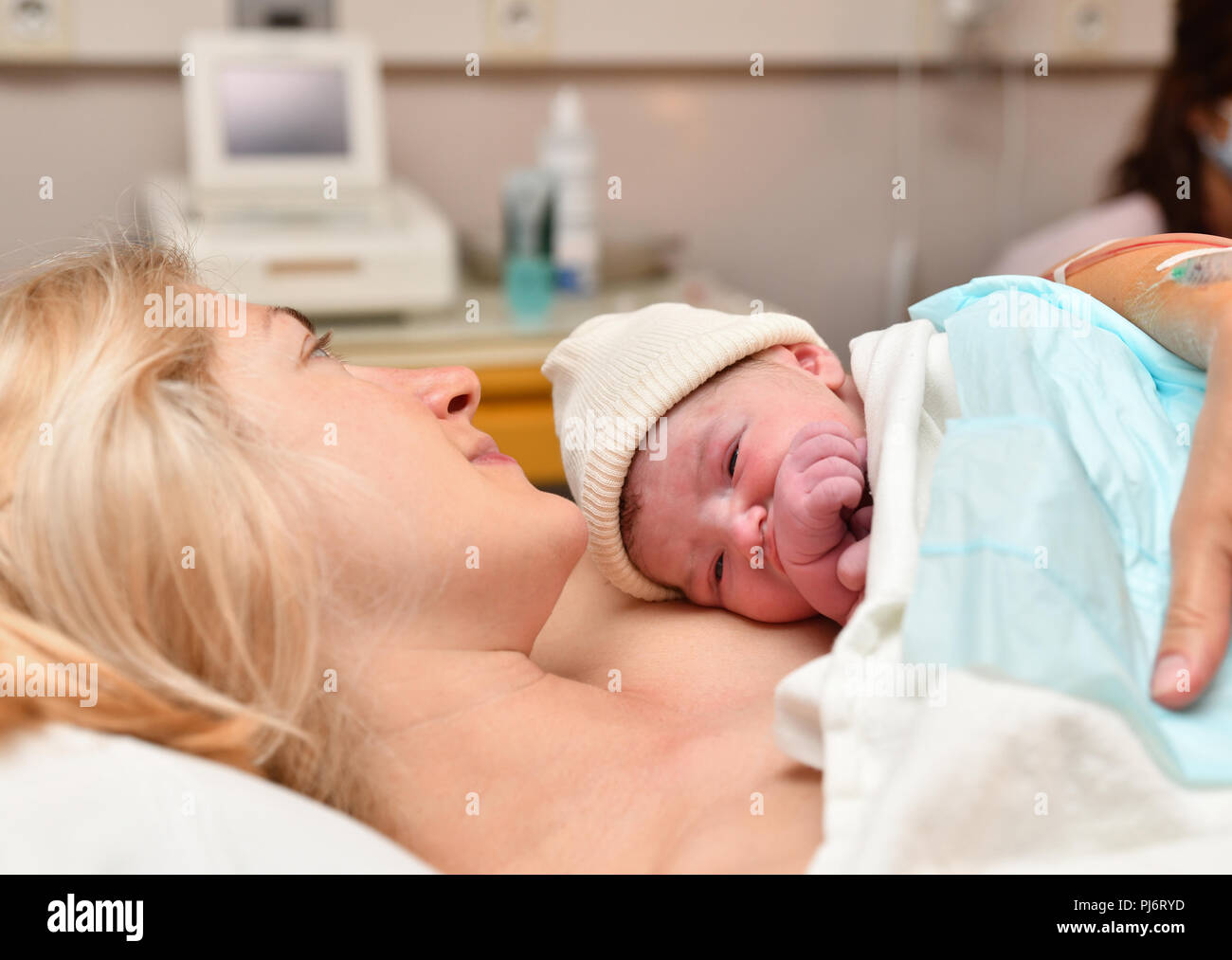 Mom and newborn baby skin to the skin after birth in the hospital Stock Photo
