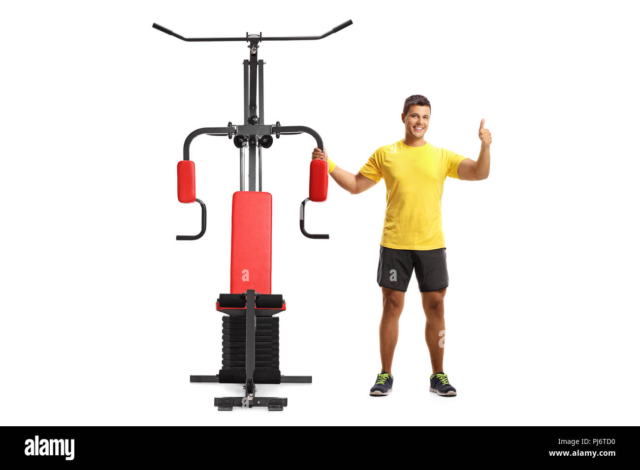 young man with an exercising machine showing tumbs up isolated on