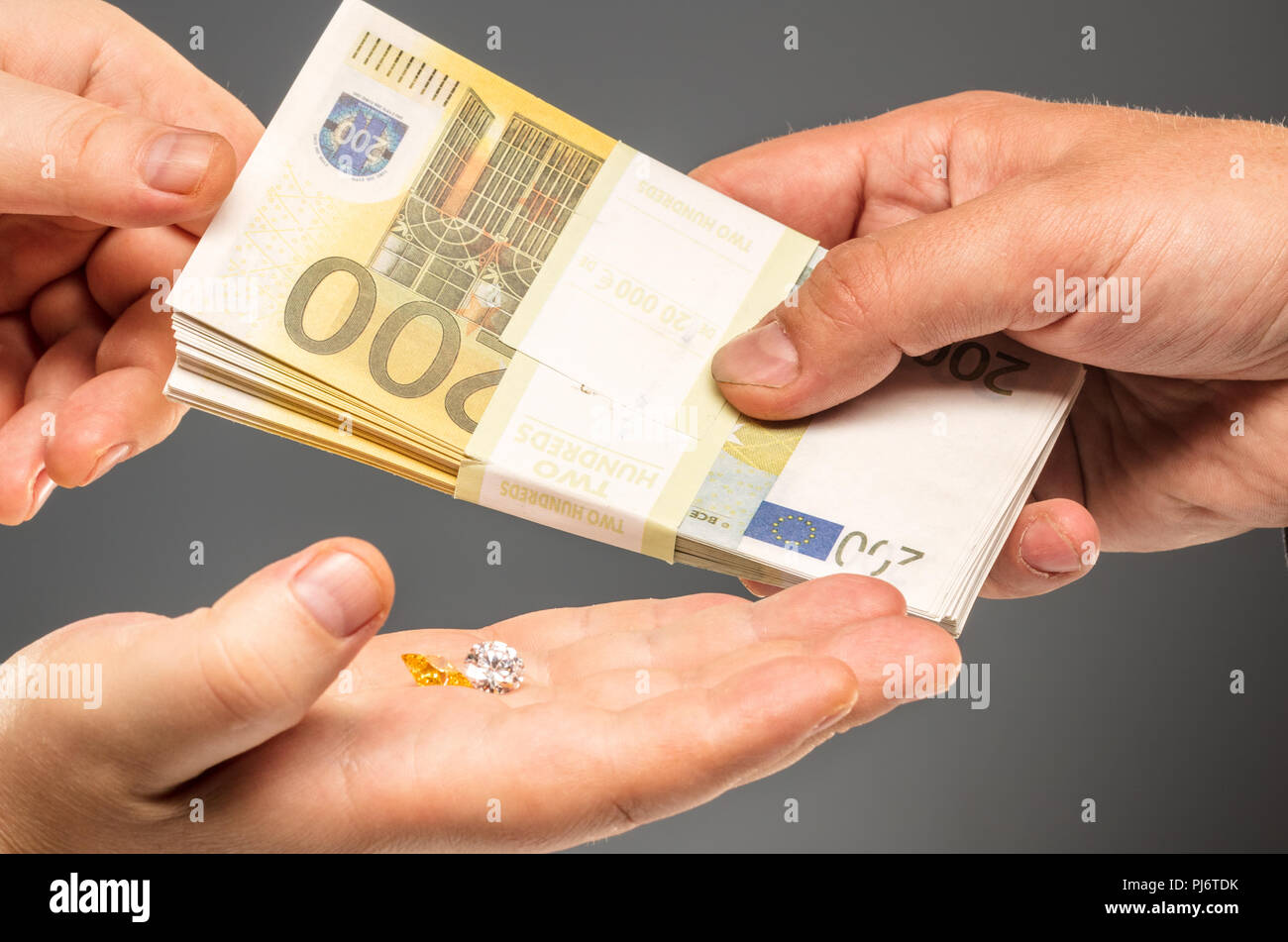 Hands exchange precious stones for the euro Stock Photo
