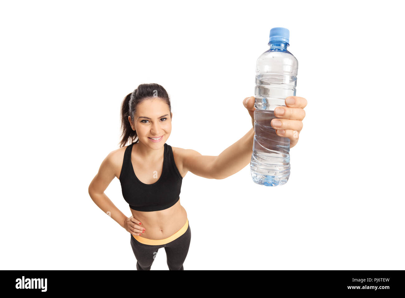 Young smiling female in sport clothing holding a botle of water isolated on white background Stock Photo