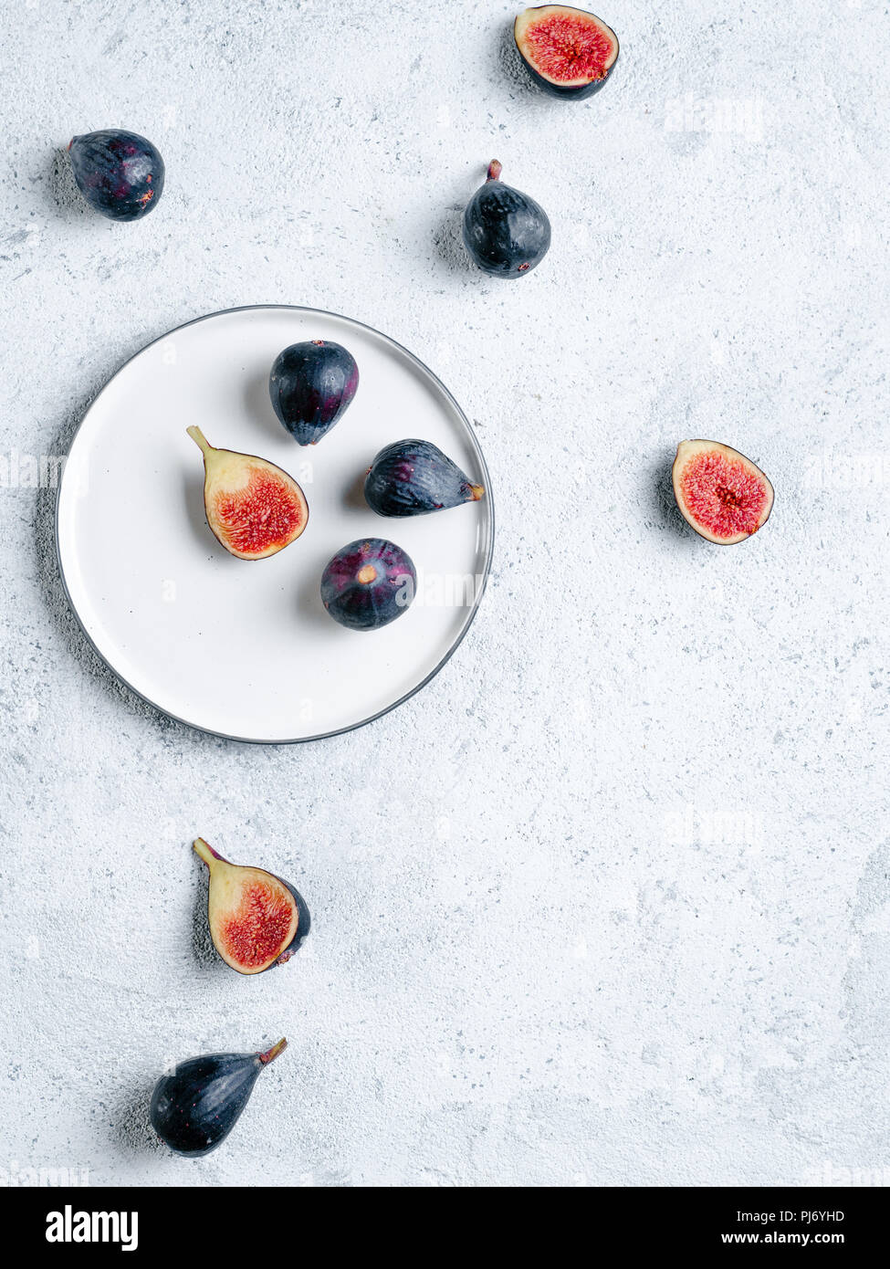 Half and whole figs on gray cement or stone background. Ripe violet