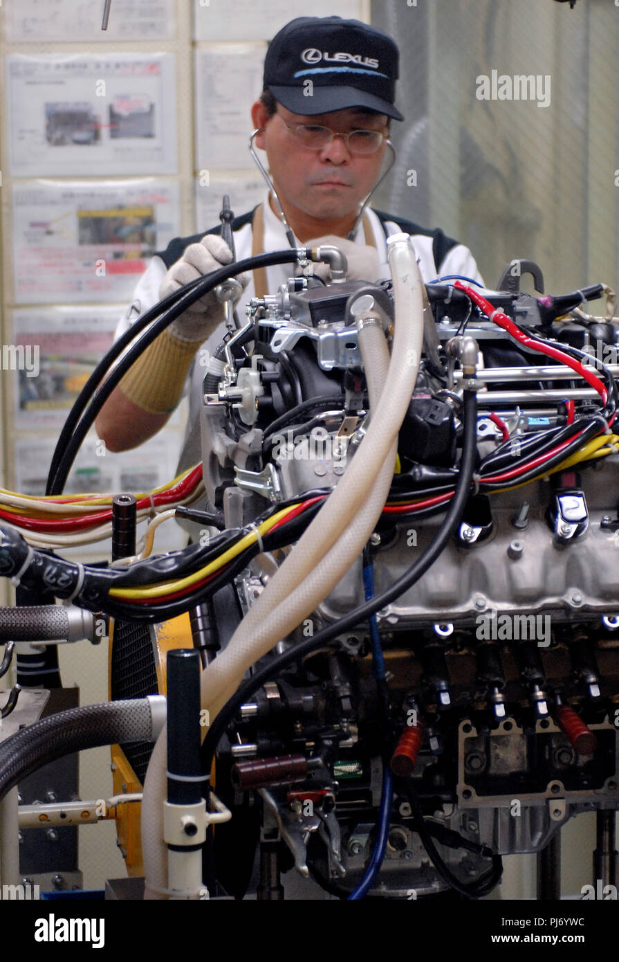 A worker uses a stethoscope-type instrument to tune the engine of a top-of-the-range Toyota Motor Corp. Lexus vehicle at the Toyota's Tahara plant in  Stock Photo