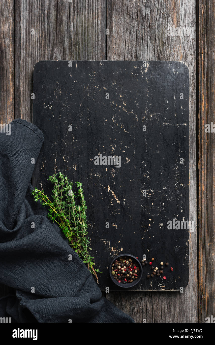 Black cutting board, spices and herbs for cooking. Top view, copy space for text Stock Photo