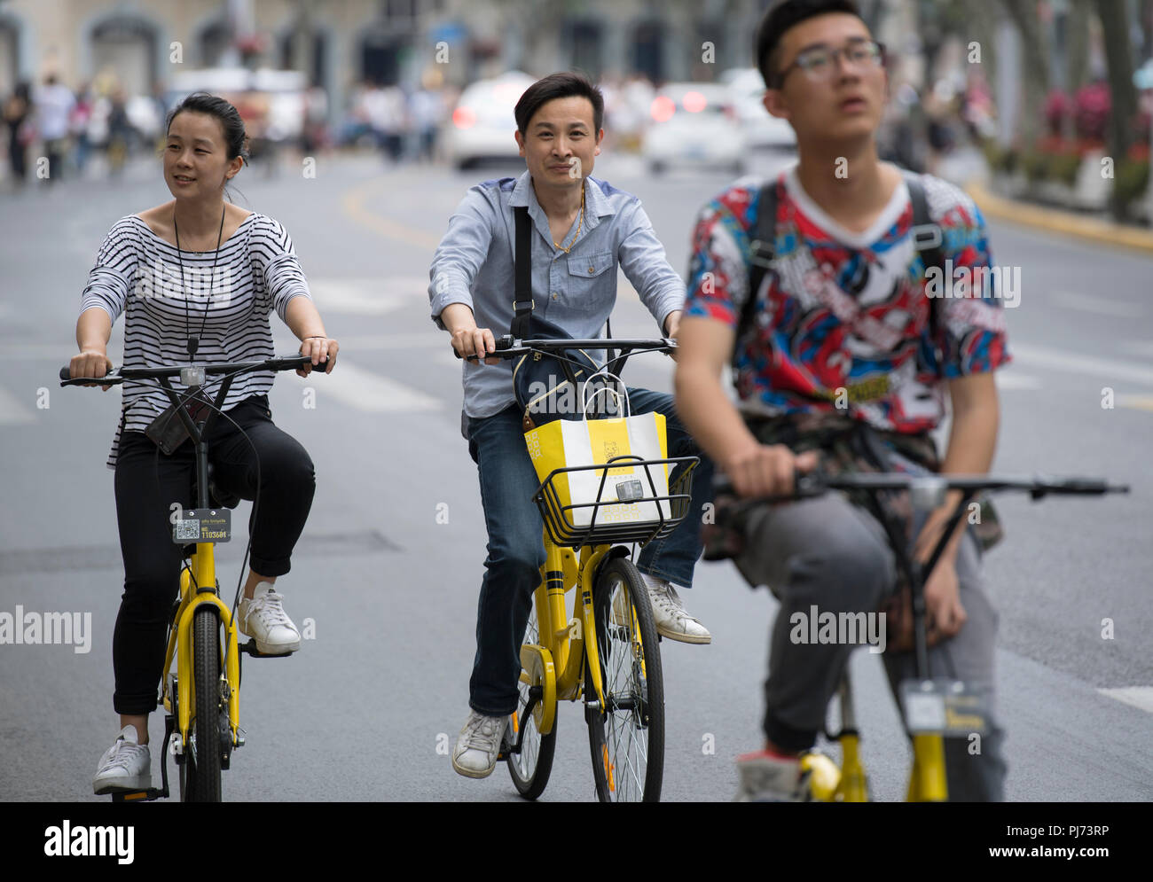 People riding bikes on the streets of Shanghai in China Stock Photo
