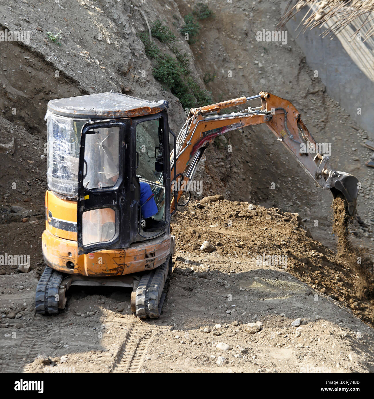 Mini excavator digging earth at construction site Stock Photo Alamy