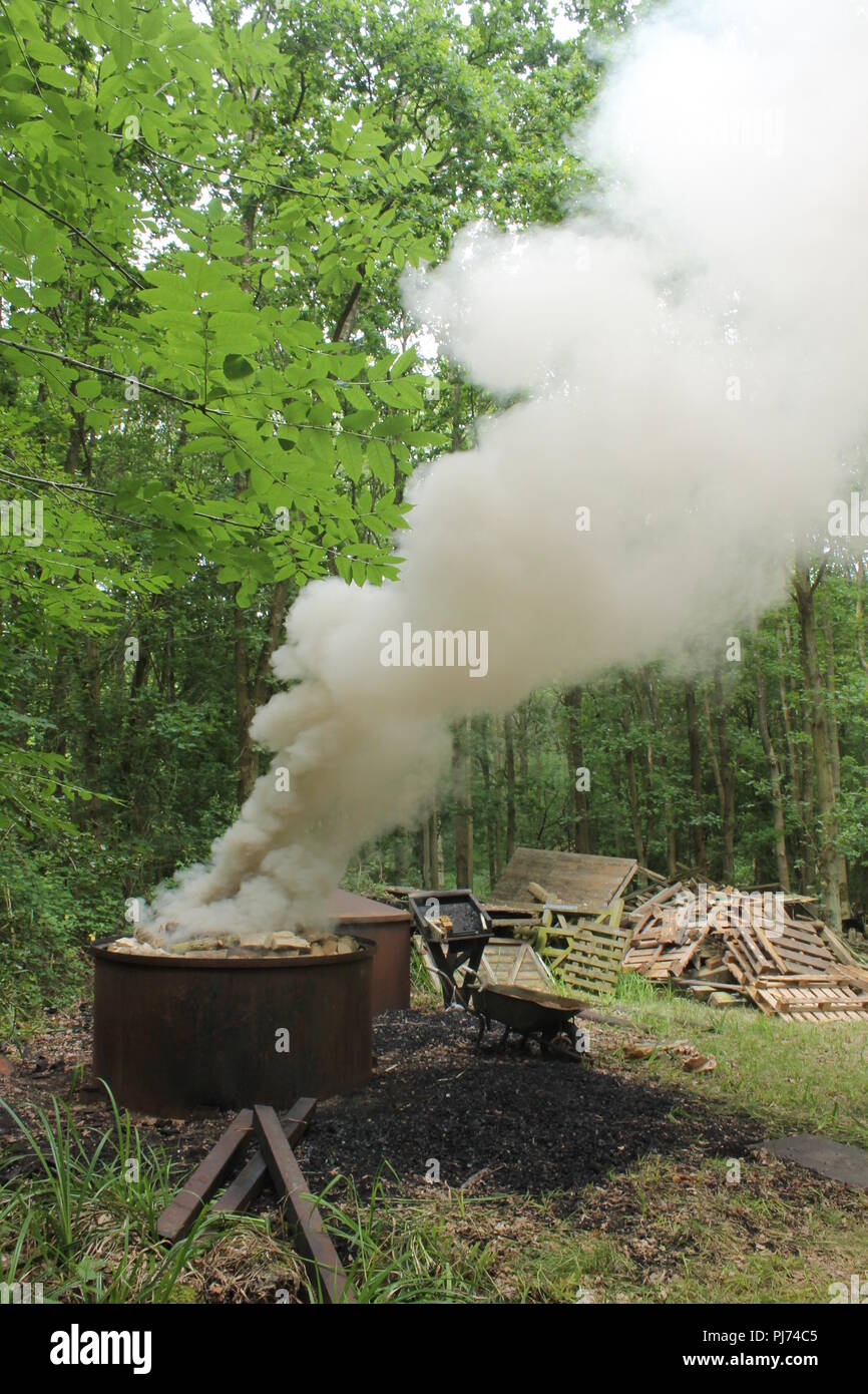 a charcoal kiln smoking in an English woodland Stock Photo Alamy