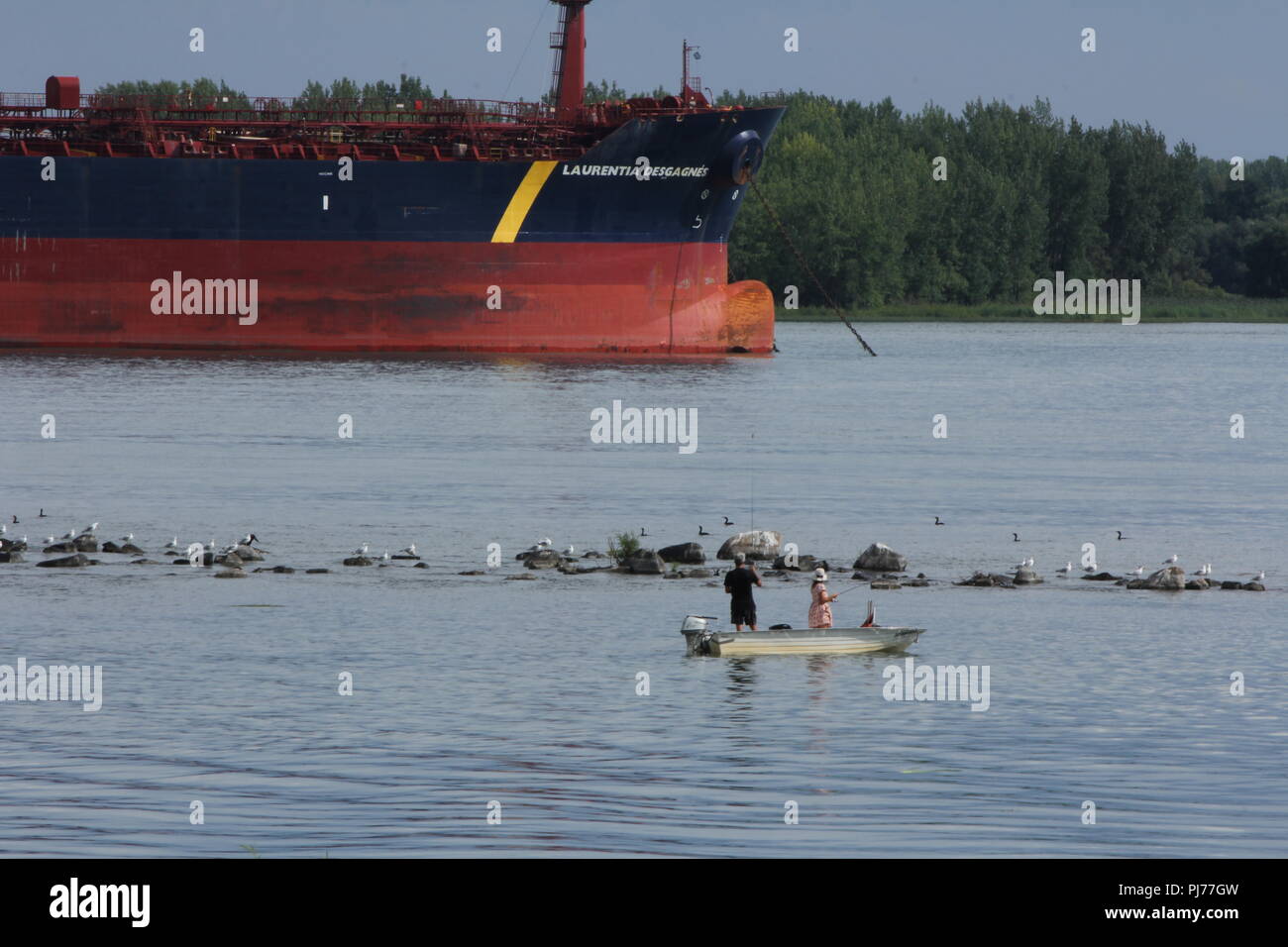 Fishing facing tanker boat on the St-Lawrence River Stock Photo