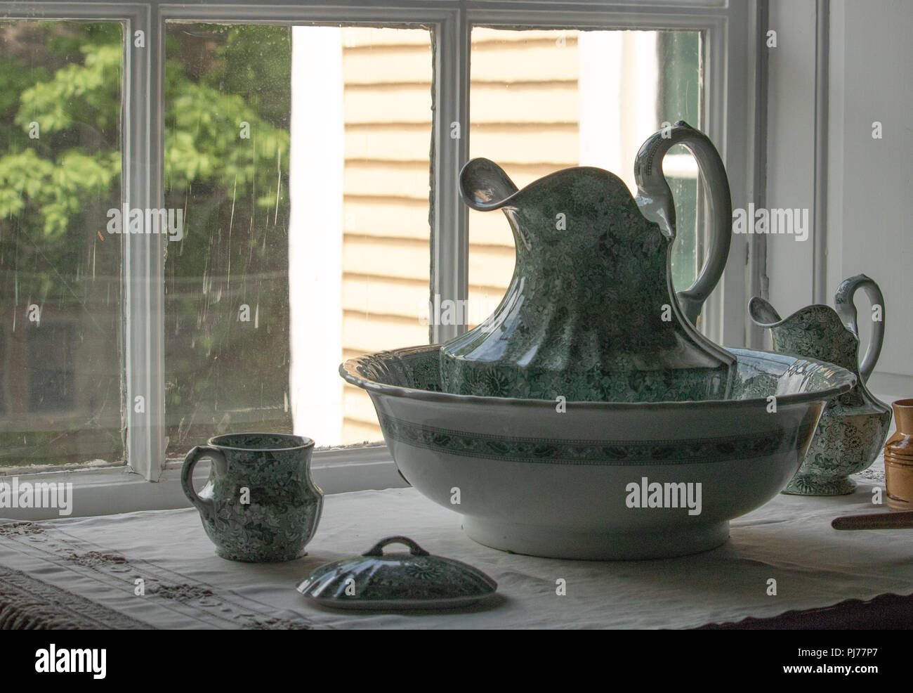 Antique pitcher and bowl from 1800s sitting on washstand, romantic vintage Victorian elegance Stock Photo
