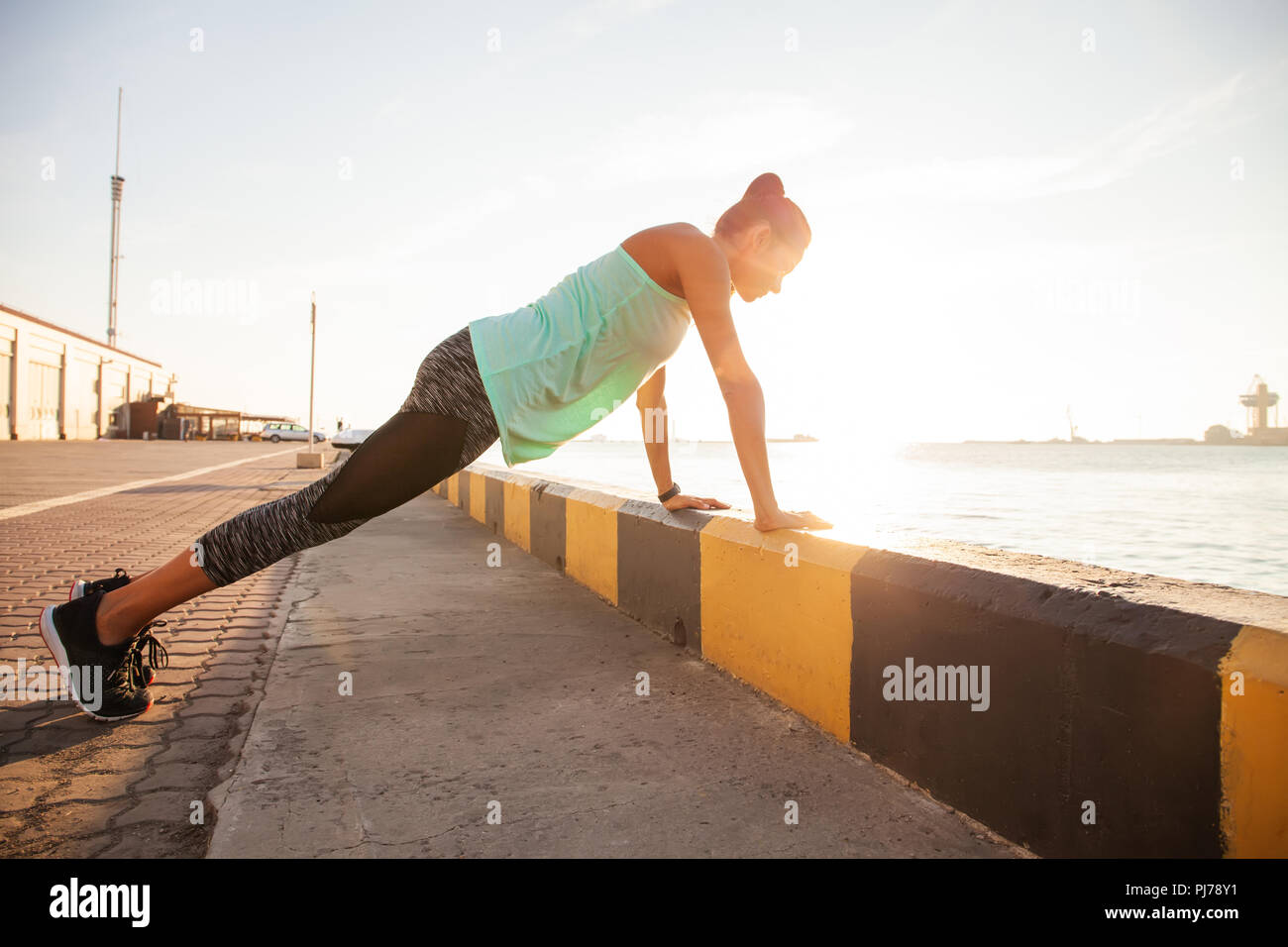 Fitness woman doing push ups Outdoor training workout summer evening side view Concept sport