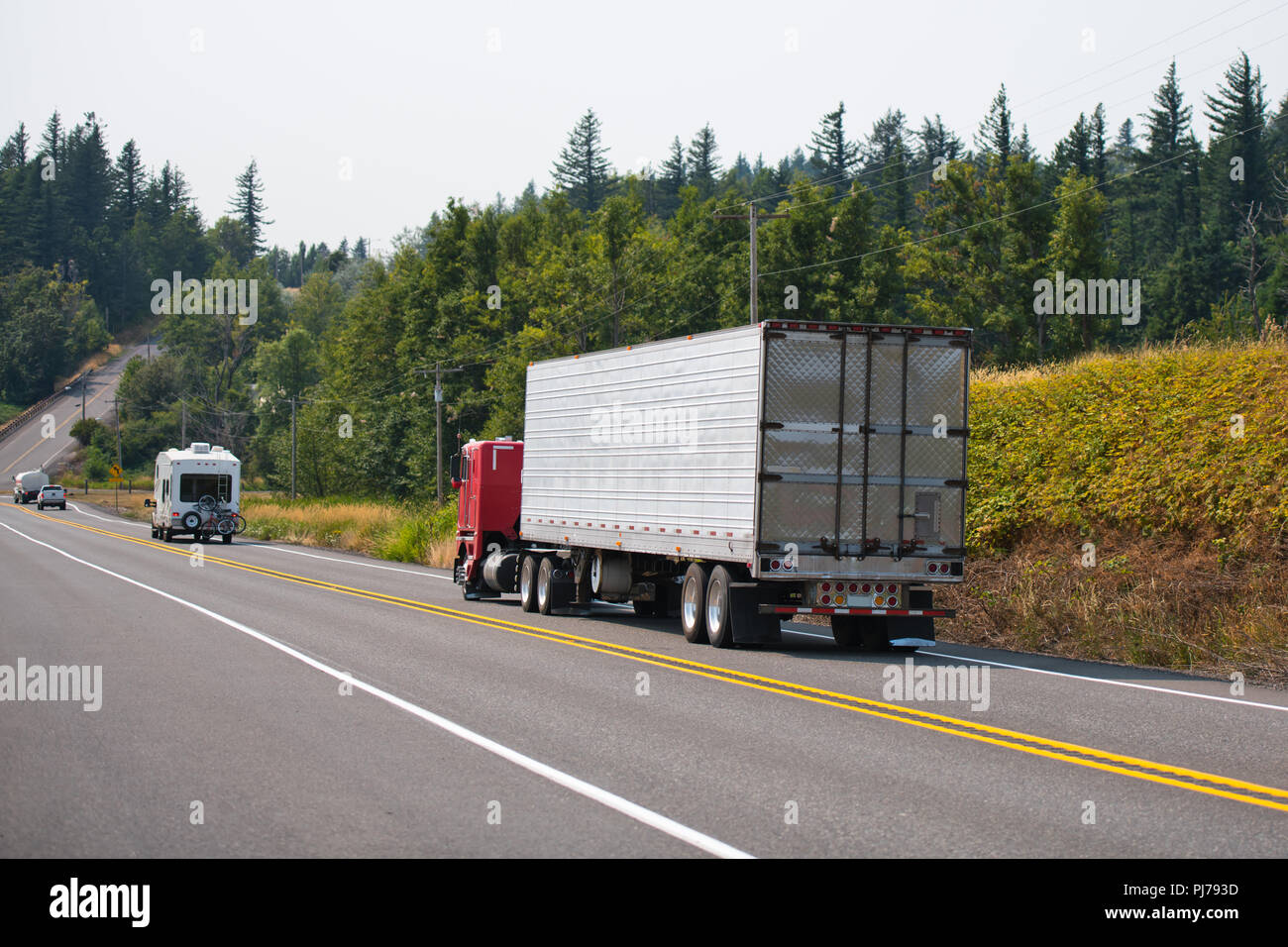 Red old fashion big rig cabover semi truck transporting frozen cargo