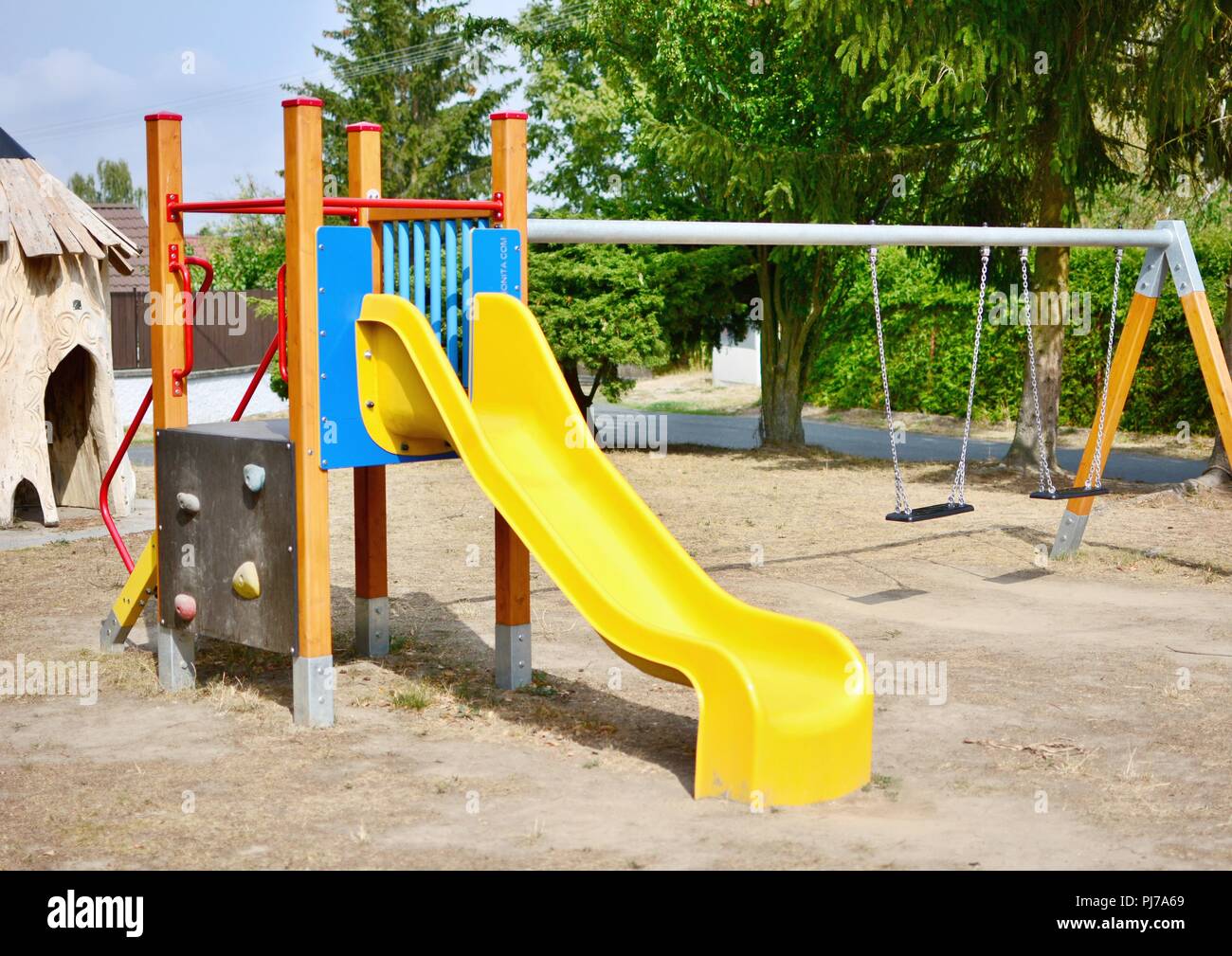 Yellow slide and chain swings in the empty playground Stock Photo Alamy