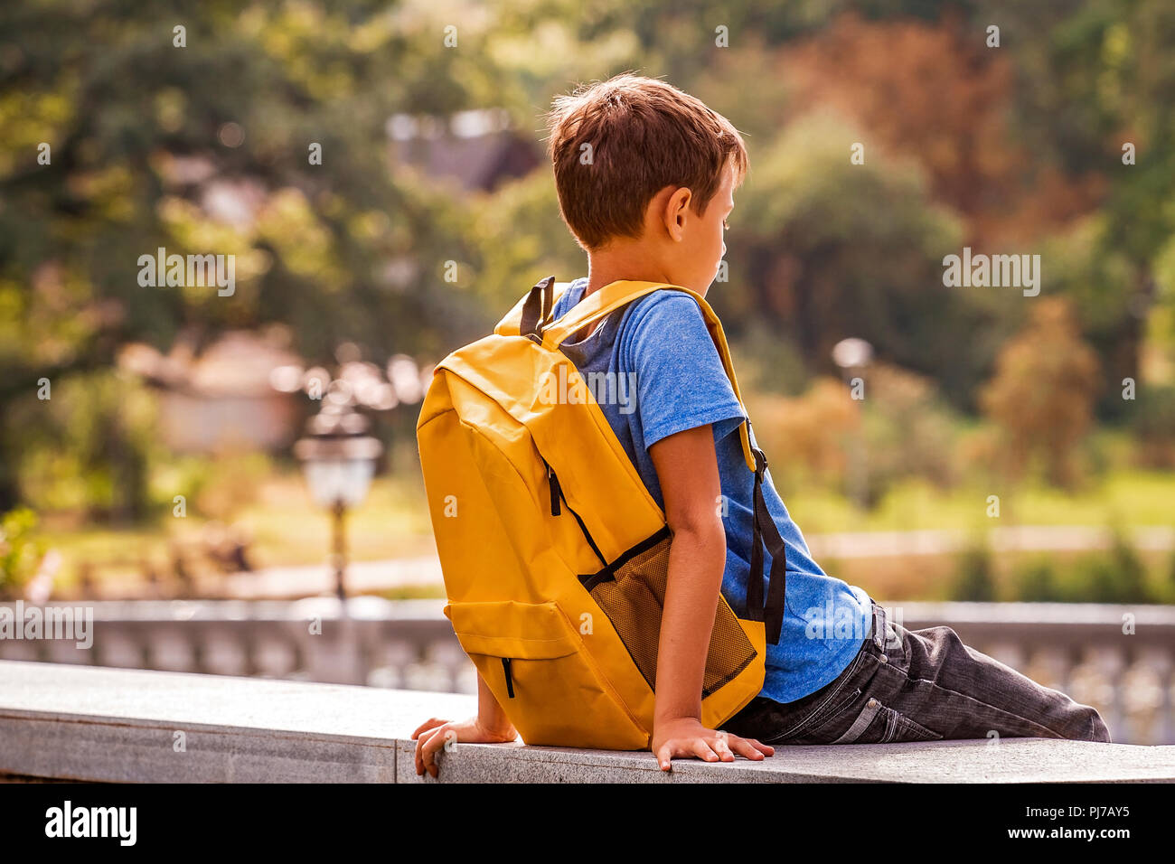 Sad alone boy sitting in the park outdoors Stock Photo - Alamy