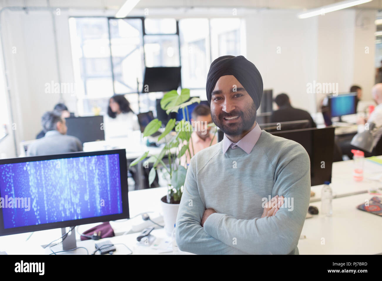Portrait smiling, confident Indian computer programmer in turban in office Stock Photo