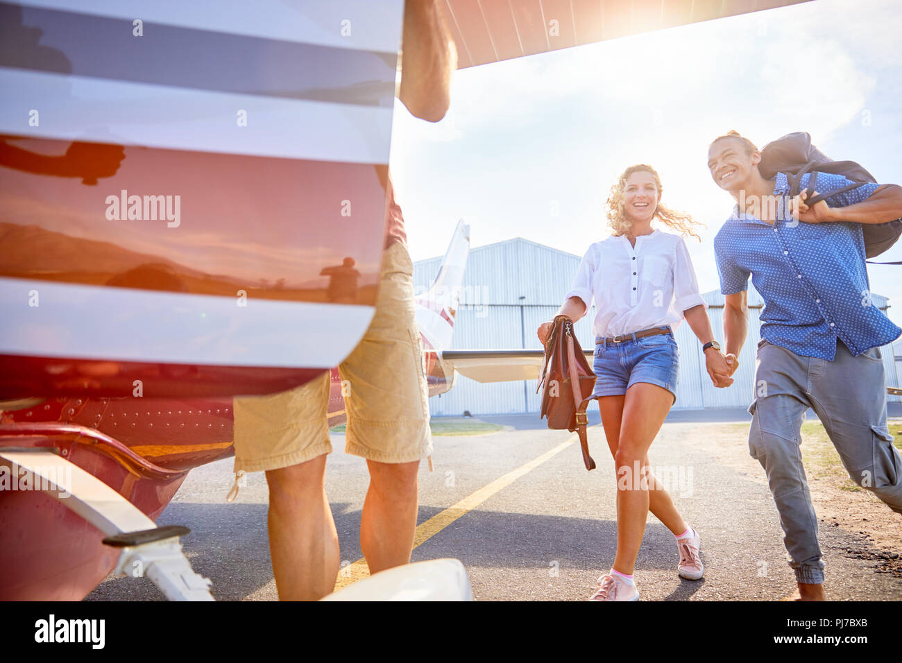 Happy, eager couple boarding small airplane Stock Photo