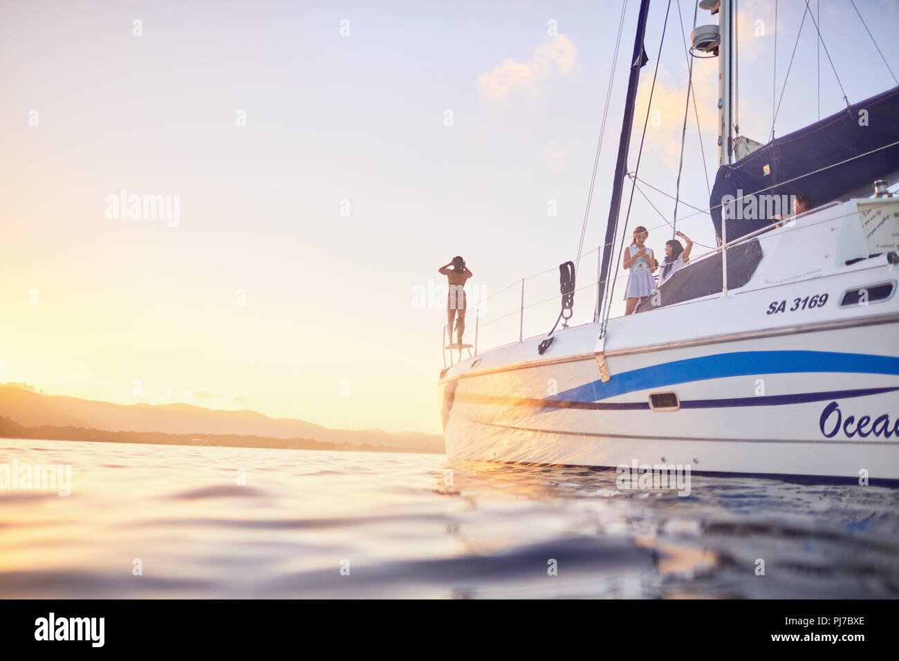 Friends on catamaran at sunset Stock Photo