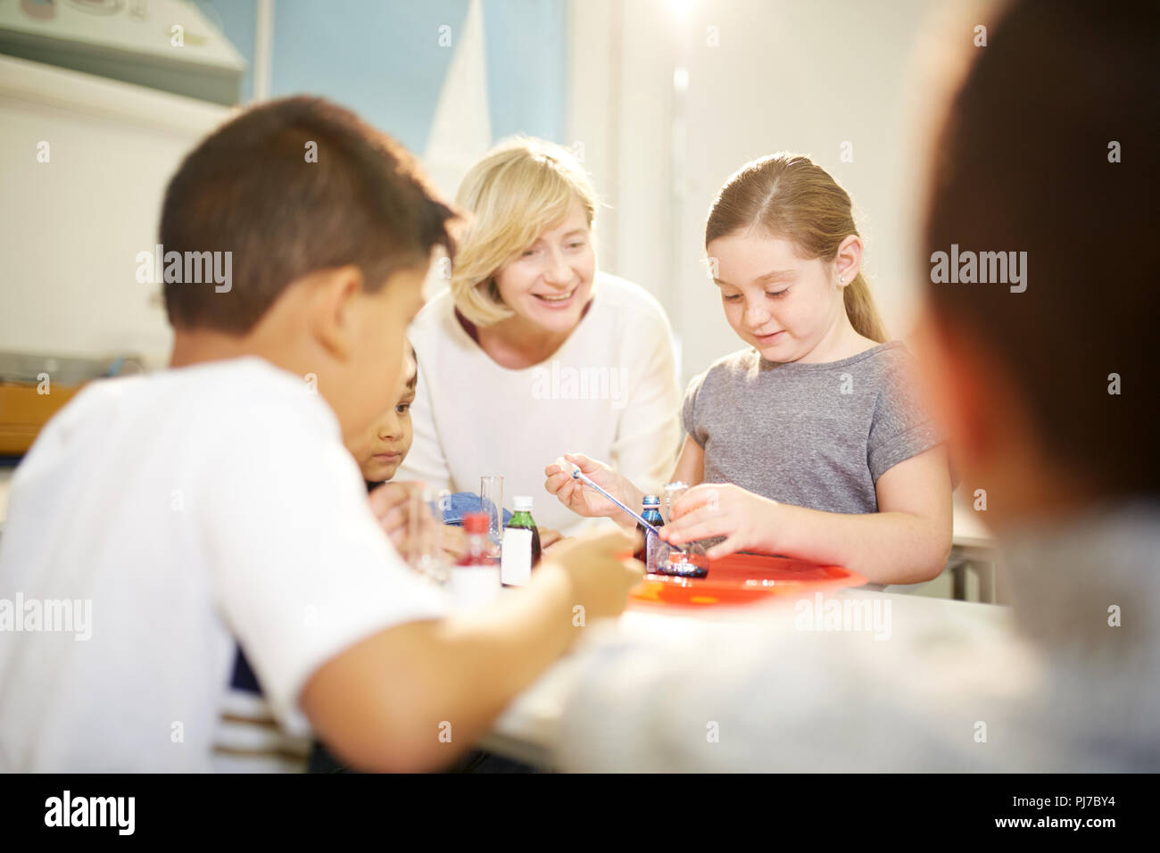 Teacher and students conducting scientific experiment Stock Photo