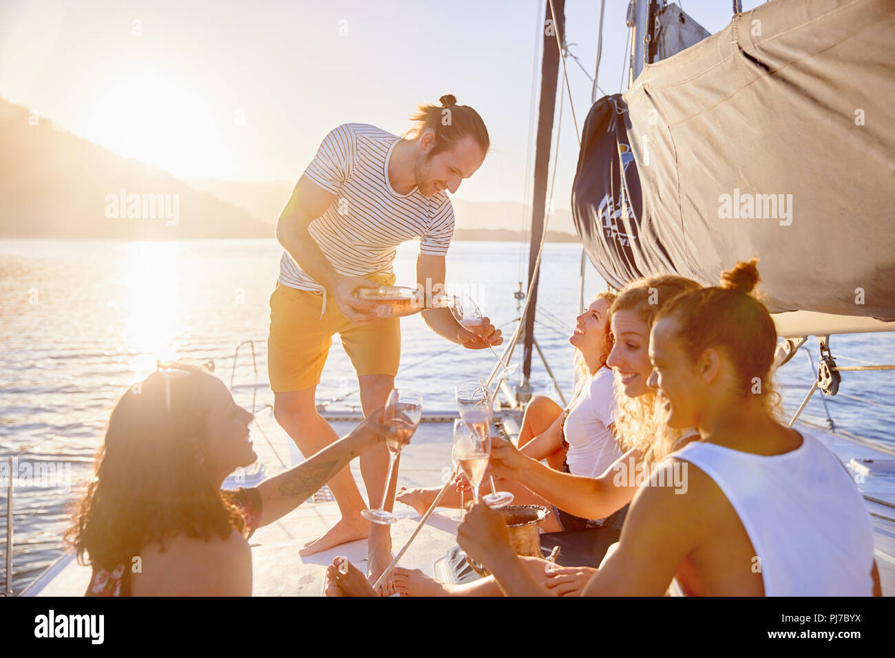 Friends drinking champagne on sunny catamaran Stock Photo