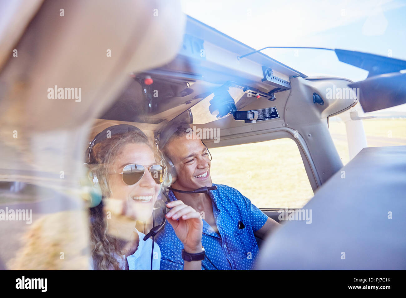Happy pilot and copilot couple flying airplane Stock Photo