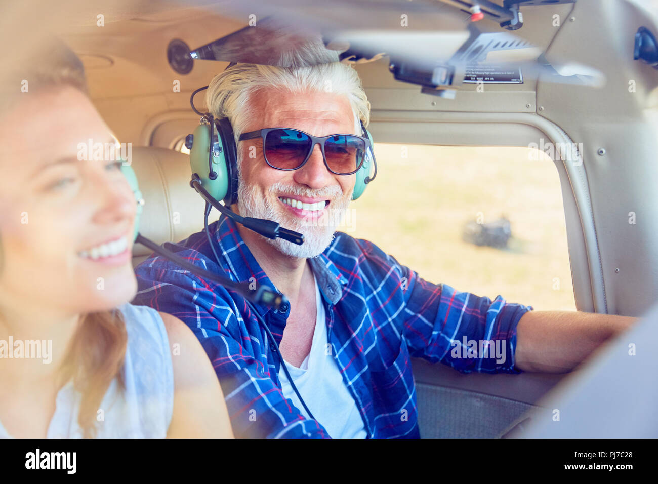 Smiling pilot flying airplane Stock Photo