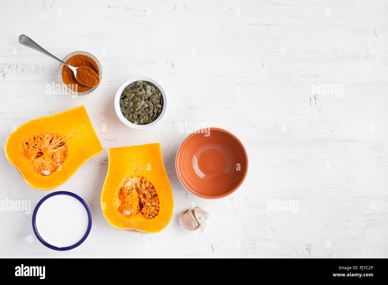 Spicy butternut squash soup ingredients on the white wooden table with copy space for text, top view Stock Photo