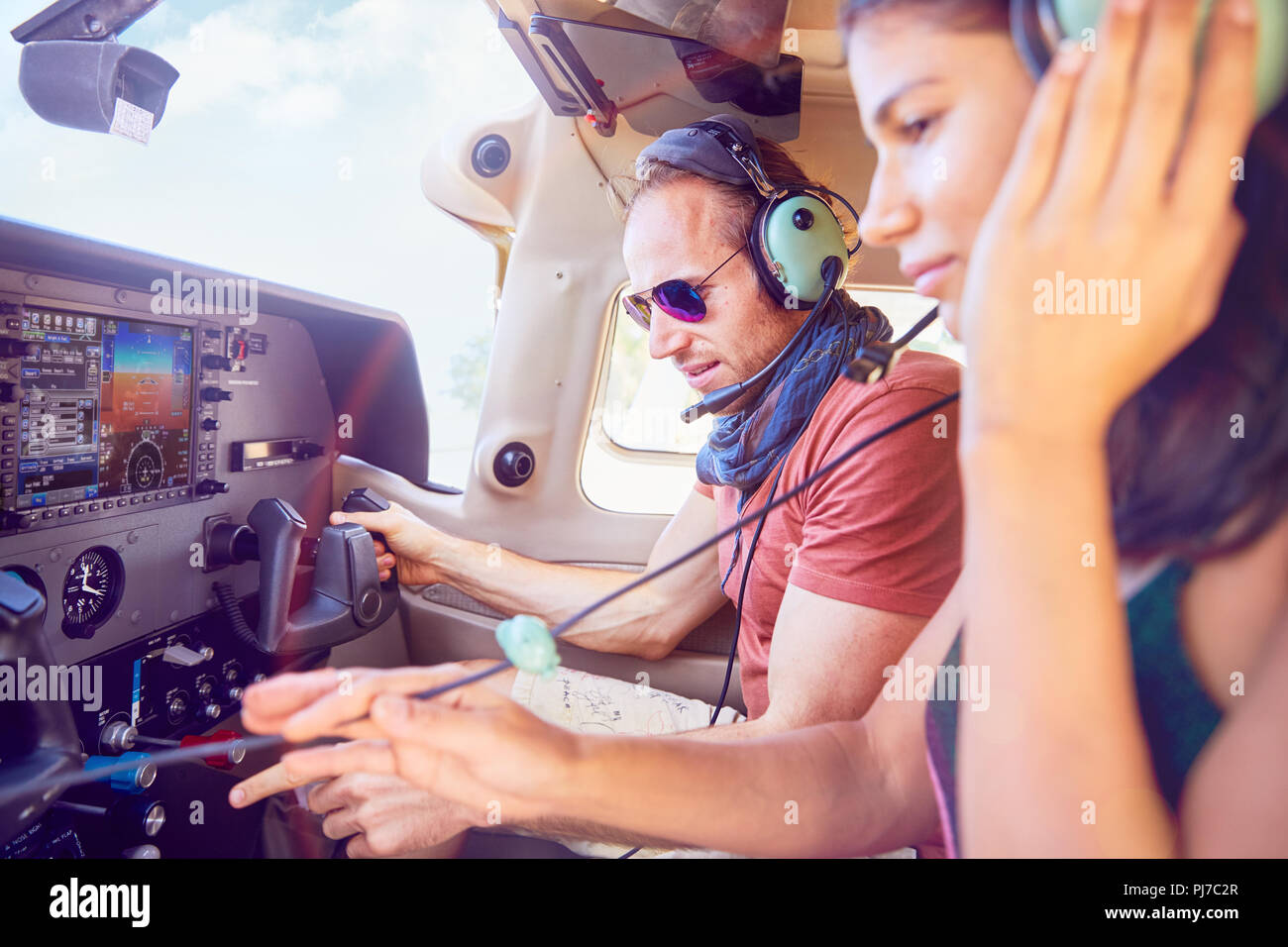 Pilot and copilot flying airplane, checking navigational equipment Stock Photo