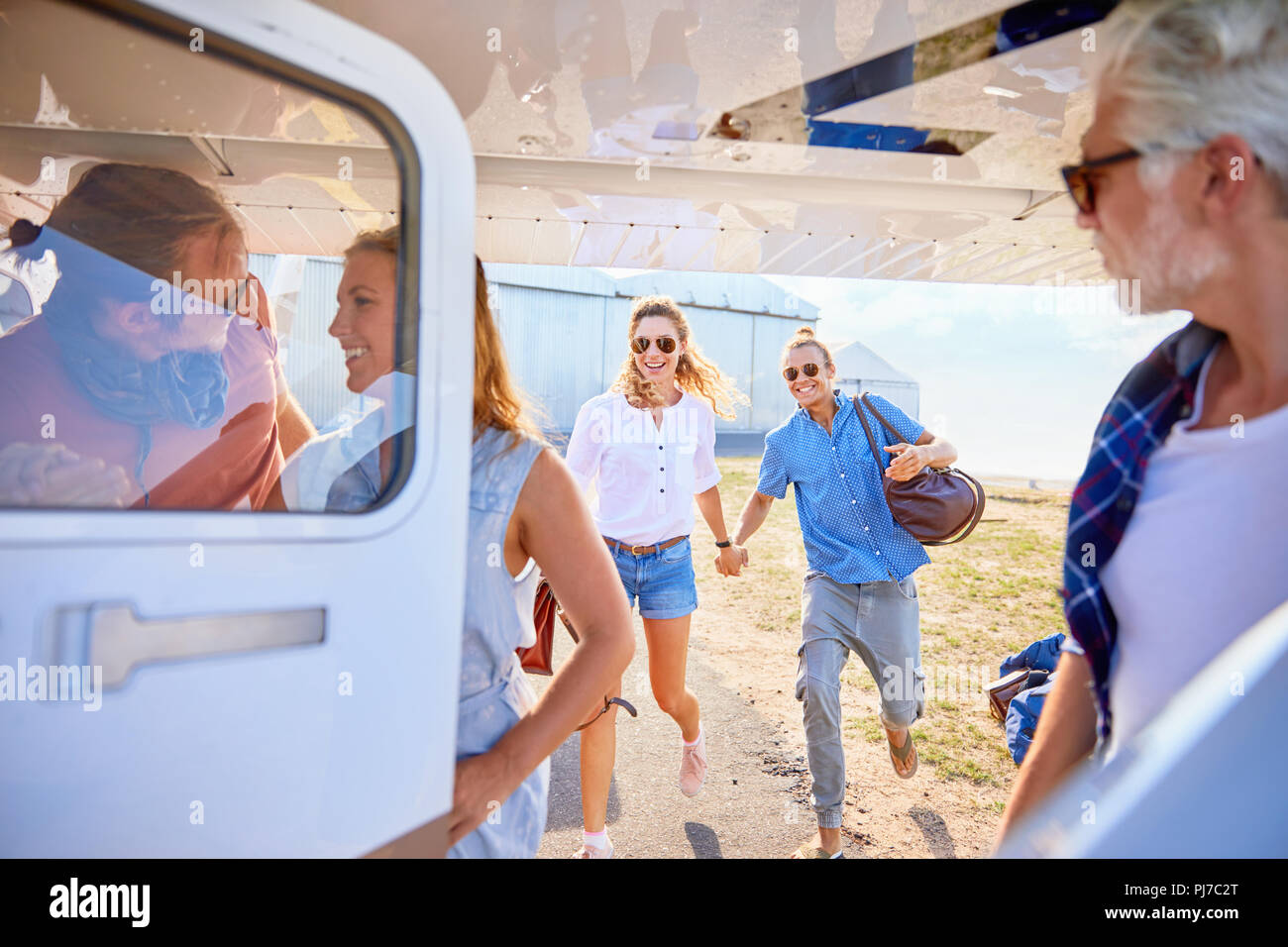 Friends boarding small airplane Stock Photo
